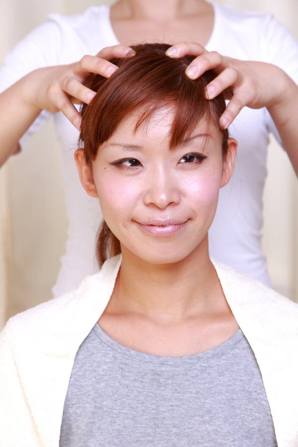 Ung japansk kvinna som får en head massage  royaltyfri fotografi Ung japansk kvinna som får en head massage  royaltyfri fotografi